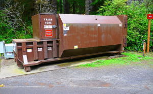 Large Outdoor Trash Compactor Surrounded by Trees and Greenery
